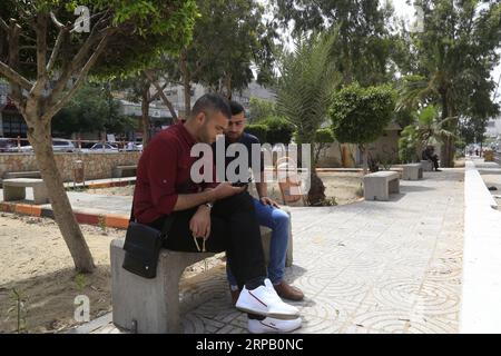 (190523) -- GAZA, May 23, 2019 -- Palestinian young men Amin Abed (L) and Mohammed al-Bourno use their phones to work on an online campaign in Gaza City, May 22, 2019. A group of Palestinian youths in the Gaza Strip have established an online campaign to refute the Israeli narration. TO GO WITH Feature: Palestinian youths launch campaign to refute Israeli narrations Stringer) MIDEAST-GAZA-ONLINE CAMPAIGN zhaoyue PUBLICATIONxNOTxINxCHN Stock Photo