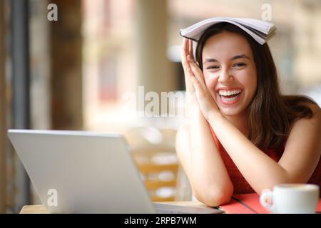 Happy student e-learning and joking laughing looking at you in a bar Stock Photo