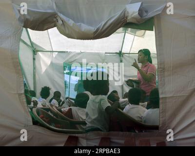 (190603) -- PAMPANGA PROVINCE, June 3, 2019 -- A teacher gives lessons to children from the indigenous group Aeta during the first day of classes in temporary classrooms of Diaz Elementary school in Pampanga Province, the Philippines, June 3, 2019. Temporary classrooms were set up after the Aeta community s classrooms were destroyed by the earthquake last April, as today marks the first day of new school year in the Philippines. ) PHILIPPINES-PAMPANGA PROVINCE-FIRST DAY OF SCHOOL ROUELLExUMALI PUBLICATIONxNOTxINxCHN Stock Photo