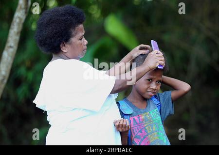 (190603) -- PAMPANGA PROVINCE, June 3, 2019 -- A mother and her son from the indigenous group Aeta prepare for school during the first day of classes in temporary classrooms of Diaz Elementary school in Pampanga Province, the Philippines, June 3, 2019. Temporary classrooms were set up after the Aeta community s classrooms were destroyed by the earthquake last April, as today marks the first day of new school year in the Philippines. ) PHILIPPINES-PAMPANGA PROVINCE-FIRST DAY OF SCHOOL ROUELLExUMALI PUBLICATIONxNOTxINxCHN Stock Photo