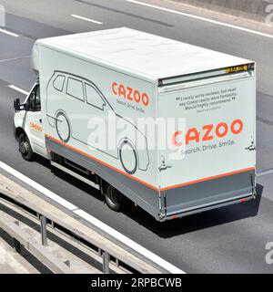 Cazoo car sales & delivery business using single commercial vehicle transporter advertising on side & back driving on M25 motorway road in England UK Stock Photo