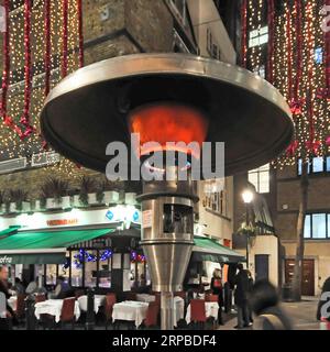 Close up heating element of Calor Gas outdoor space heater beside restaurant tables at Christmas in St Christophers Place West End London England UK Stock Photo