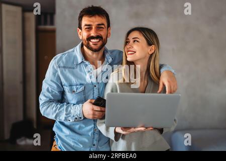 Couple of young designers working at modern home office, two coworkers discussing fun project Stock Photo