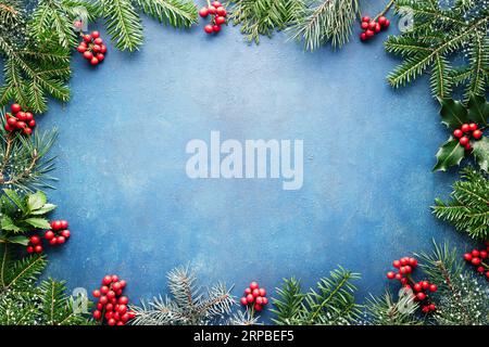 Christmas background with fir tree and holly berries with copy space. Stock Photo