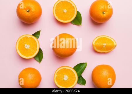 Fruit pattern of fresh orange slices on colored background. Top view. Copy Space. creative summer concept. Half of citrus in minimal flat lay. Stock Photo