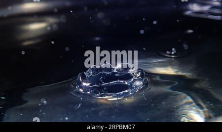 Clear aqua water droplet splashing in concentric circles, capturing refreshing purity. Stock Photo