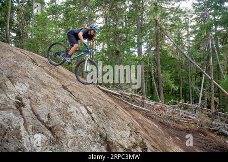 Woman mountain biking in forest, Lost Lake Trails, Whistler, British Columbia, Canada Stock Photo