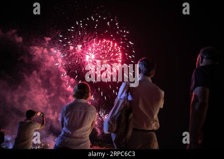 (190625) -- ATHENS, June 25, 2019 -- People view a fireworks show for the opening of the Summer Nostos (Homecoming) Festival at the Stavros Niarchos Foundation Cultural Center in Athens, Greece, June 23, 2019. Greek artist Alkistis Protopsalti, one of the most acclaimed and popular singers in the past four decades in Greece, sang a Chinese song during her performance in a festival in Athens on Sunday evening, enthralling the audience. TO GO WITH Feature: Greek artist Alkistis Protopsalti sings Chinese song, enthralling audience of Athens festival ) GREECE-ATHENS-SUMMER NOSTOS FESTIVAL-CHINESE Stock Photo