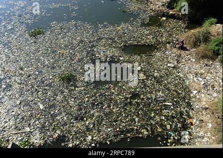 (190626) -- BANDUNG, June 26, 2019 -- A man fishes by the Citarum river which is covered by plastic waste in Bandung, West Java, Indonesia, June 26, 2019. h) INDONESIA-BANDUNG-PLASTIC WASTE BukbisxChandraxIsmet PUBLICATIONxNOTxINxCHN Stock Photo