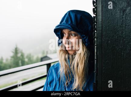 portrait of a woman stood in a doorway in a raincoat in Norway Stock Photo