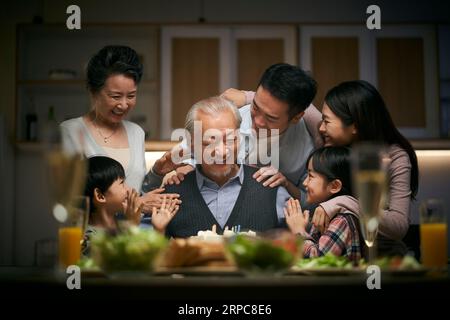happy three generation asian family celebrating grandpa's birthday at home Stock Photo