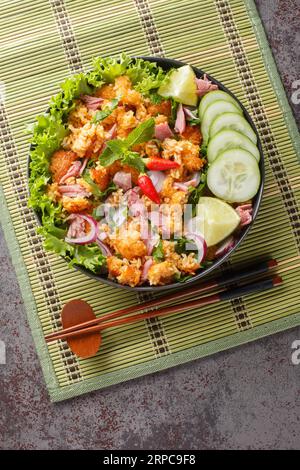 Fried rice with fermented pork and vegetables Thai food Khao Pad Naem closeup on the plate on the table. Vertical top view from above Stock Photo