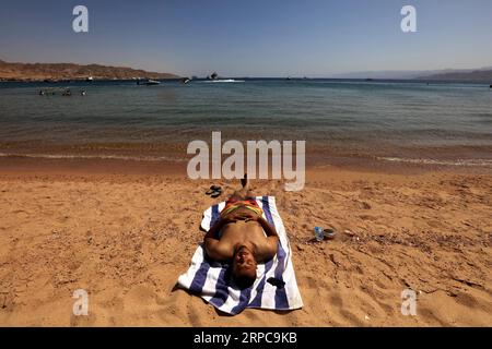 (190628) -- AQABA (JORDAN), June 28, 2019 -- A tourist enjoys leisure on the beach of the Red Sea in the southern port city of Aqaba, Jordan, on June 28, 2019. Aqaba attracts tourists from Jordan and abroad to enjoy their summer holidays with its famous beaches and various water sports. ) JORDAN-AQABA-RED SEA-TOURISM MohammadxAbuxGhosh PUBLICATIONxNOTxINxCHN Stock Photo