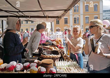 (190629) -- TURKU (FINLAND), June 29, 2019 -- Tourists queue for traditional candy apples in Turku, southwestern Finland, on June 29, 2019. The annual Medieval Market, one of the largest historical events in Finland, is held in Turku from June 27 to June 30. Modern people can enjoy ancient music and dance, historical street plays, traditional food and handicrafts during the event. ) FINLAND-TURKU-MEDIEVAL MARKET ZhangxXuan PUBLICATIONxNOTxINxCHN Stock Photo