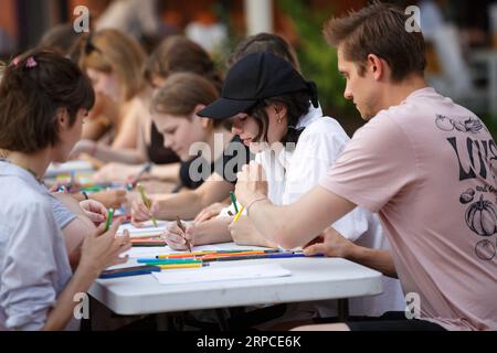 Moscow, Russia, August 27, 2022: Open Lessons. Master class on drawing. A group of people learning how to draw creatively at a large table Stock Photo