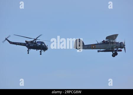 A Westland Wasp helicopter and a Royal Navy Fairey Swordfish torpedo bomber performing their routine at the Bournemouth Air Festival 2023, Bournemouth, UK Stock Photo