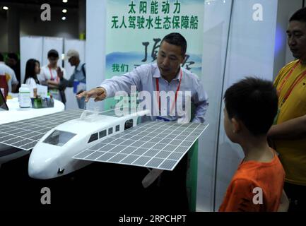 (190705) -- DALIAN, July 5, 2019 -- An exhibitor introduces a model of solar-powered boat to visitors during the 20th China Overseas Scholar Innovation Summit in Dalian, northeast China s Liaoning Province, July 5, 2019. The 20th China Overseas Scholar Innovation Summit kicked off here on Friday. Lyu Wenzheng) CHINA-DALIAN-OVERSEAS SCHOLAR INNOVATION SUMMIT-OPENING (CN) LvxWenzheng PUBLICATIONxNOTxINxCHN Stock Photo