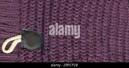 Patterned cardigan fabric made of wool. Handmade knitted fabric purple wool sweater background texture Stock Photo
