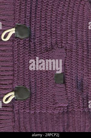 Patterned cardigan fabric made of wool. Handmade knitted fabric purple wool sweater background texture Stock Photo