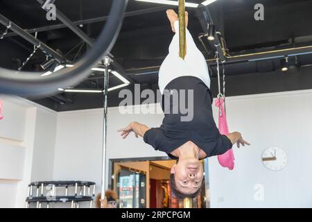 (190711) -- JILIN, July 11, 2019 -- Jiang Zhijun practices pole dancing in the dance room in Jilin City, northeast China s Jilin Province, July 10, 2019. A group of dama, refering to the legions of usually middle aged women, formed a team of pole dancing in Jinlin City, northeast China s Jilin Province in 2016. The team has eight members with an average age of 64. Pole dancing is known for its softness and strength, says Jiang Zhijun, the 68-year-old team leader. We started with basic strength training, then went forward to perform high-level moves gradually. The team competed in many domestic Stock Photo