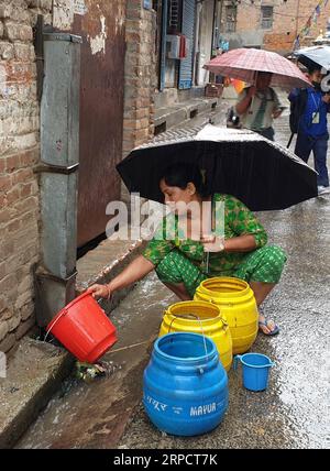 (190712) -- KATHMANDU, July 12, 2019 -- A woman collects rainwater during rainfall in Kathmandu, Nepal, July 12, 2019. Nepal has been hit by heavy rainfall since Thursday evening. ) NEPAL-KATHMANDU-MONSOON-RAINFALL sunilxsharma PUBLICATIONxNOTxINxCHN Stock Photo