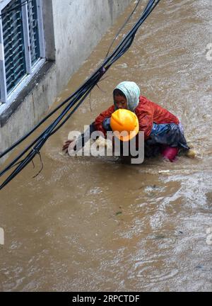 (190712) -- KATHMANDU, July 12, 2019 -- A rescuer saves a woman from the flood in Kathmandu, Nepal, July 12, 2019. Many areas in Nepal were inundated by the swollen Balkhu river following torrential rains since Thursday night. ) NEPAL-KATHMANDU-RAIN-FLOOD sunilxsharma PUBLICATIONxNOTxINxCHN Stock Photo