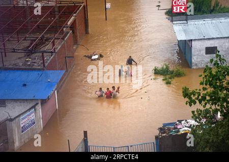 (190712) -- KATHMANDU, July 12, 2019 -- People tread in the flood in Kathmandu, Nepal, July 12, 2019. Many areas in Nepal were inundated by the swollen Balkhu river following torrential rains since Thursday night. ) NEPAL-KATHMANDU-RAIN-FLOOD sunilxsharma PUBLICATIONxNOTxINxCHN Stock Photo