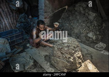 (190715) -- KOLKATA, July 15, 2019 -- A potter prepares clay to make earthenware cups, known as Bhar by the locals, at a workshop in Kolkata, India, July 15, 2019. The Bhar is a type of low cost, eco-friendly earthenware cup commonly used to serve milk or tea in Kolkata. Tumpa Mondal) INDIA-KOLKATA-CRAFT-EARTHENWARE CUPS ZhangxNaijie PUBLICATIONxNOTxINxCHN Stock Photo