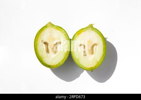 The green outer shells of the unripe walnuts are cut in half, unripe green walnuts Stock Photo