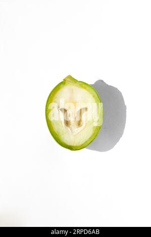 The green outer shells of the unripe walnuts are cut in half, unripe green walnuts Stock Photo