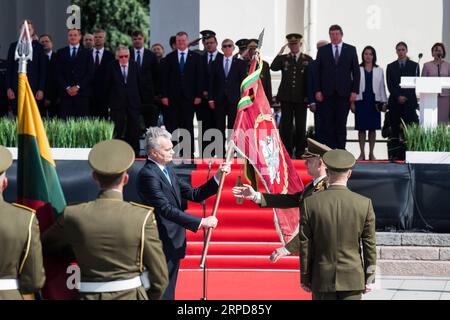 (190726) -- VILNIUS, July 26, 2019 -- Lithuanian President Gitanas Nauseda (L) passes on the flag of the Armed Forces to the new Chief of Defense Major General Valdemaras Rupsys during an inauguration ceremony in Vilnius, Lithuania, July 25, 2019. Lithuania s new Chief of Defense Major General Valdemaras Rupsys took over his duties during the solemn inauguration ceremony on Thursday, pledging to further modernize the Armed Forces of Lithuania and improve readiness and maintenance of all military units. (Photo by /Xinhua) LITHUANIA-VILNIUS-CHIEF OF DEFENCE-INAUGURATION AlfredasxPliadis PUBLICAT Stock Photo
