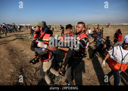 (190726) -- GAZA, July 26, 2019 (Xinhua) -- Palestinian medics carry a wounded man during clashes with Israeli troops near the Gaza-Israel border, east of Gaza City, July 26, 2019. At least 56 Palestinians were injured on Friday during clashes with Israeli soldiers in eastern Gaza Strip, close to the border with Israel, medics said. (Str/Xinhua) MIDEAST-GAZA-CLASHES PUBLICATIONxNOTxINxCHN Stock Photo