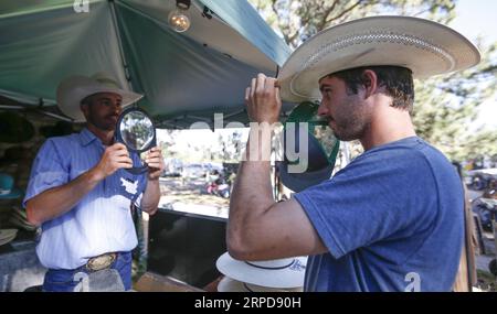 (190726) -- CHEYENNE (U.S.), July 26, 2019 -- A man tries a hat at the Cheyenne Frontier Days in Cheyenne, the United States, July 23, 2019. Cheyenne Frontier Days is held here from July 19 to 28, featuring rodeo events, concerts, parades and art shows. ) U.S.-CHEYENNE-FRONTIER DAYS LixYing PUBLICATIONxNOTxINxCHN Stock Photo