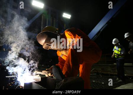 (190728) -- LUANG PRABANG, July 28, 2019 -- A Chinese engineer works on the Luang Prabang Mekong River Super Major Bridge in the north of the Luang Prabang Ancient Town, a world heritage, some 220 km north of the Lao capital Vientiane, July 27, 2019. With the concrete beam of the last span over Mekong River put in place, the main section of Luang Prabang cross-Mekong River railway bridge has been completed on Sunday, seven months ahead of schedule. The closure of the Luang Prabang Mekong River Super Major Bridge, one of the two cross-Mekong bridges along the China-Laos Railway, indicated that Stock Photo