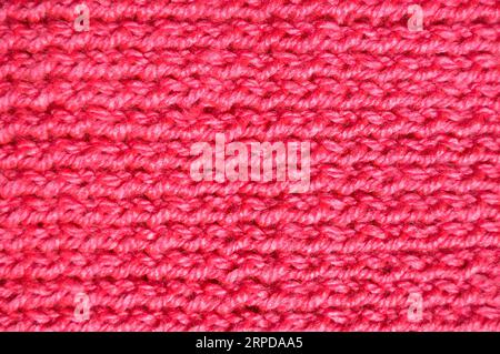 Pattern fabric made of wool. Handmade knitted fabric pink and red wool background texture Stock Photo