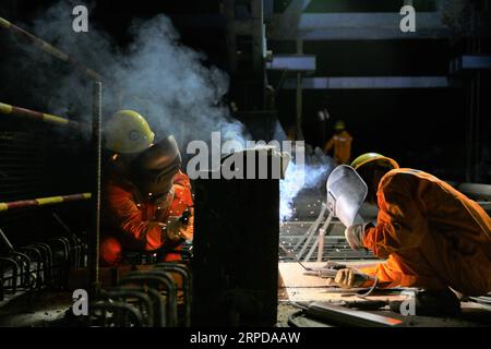(190728) -- LUANG PRABANG, July 28, 2019 -- Chinese engineers weld on the Luang Prabang Mekong River Super Major Bridge in the north of the Luang Prabang Ancient Town, a world heritage, some 220 km north of the Lao capital Vientiane, July 27, 2019. With the concrete beam of the last span over Mekong River put in place, the main section of Luang Prabang cross-Mekong River railway bridge has been completed on Sunday, seven months ahead of schedule. The closure of the Luang Prabang Mekong River Super Major Bridge, one of the two cross-Mekong bridges along the China-Laos Railway, indicated that th Stock Photo