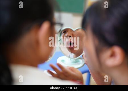 (190731) -- NANCHANG, July 31, 2019 -- Liu Xiaoqing demonstrates her mouth shape during a voice and speech training at the Luxi County Special Education School in Luxi County of Pingxiang, east China s Jiangxi Province, July 3, 2019. When the Luxi County Special Education School was established in 1997, Liu Xiaoqing, then a normal university graduate, applied for a post there without hesitation. Working as a special education teacher has been challenging, as Liu s students need far more attention than their peers without physical or mental disabilities. But Liu stayed on her post for 22 years Stock Photo