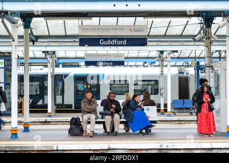 GUILDFORD, SURREY, UK- AUGUST 31, 2023: Guildford Railway Station- station signage and people waiting on platform Stock Photo
