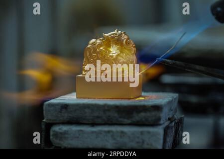 (190801) -- BEIJING, Aug. 1, 2019 -- A worker welds two parts of the Beijing 2022 Winter Olympic Games emblem seal together, July 29, 2019. Authorized by the Beijing Organizing Committee of the Olympic and Paralympic Winter Games, emblem seals made of Hetian greenish white jade and gold were set to be issued with limited numbers later this week, announced the BOCOG on July 31, 2019. A total of 2,022 jade seals and 5,000 gold ones will be released to the market on Saturday, according to the organizers. ) XINHUA PHOTOS OF THE DAY ZhangxYuwei PUBLICATIONxNOTxINxCHN Stock Photo
