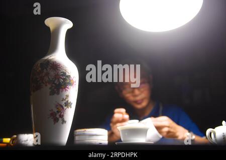 (190805) -- NANCHANG, Aug. 5, 2019 -- Mao Guanghui works on a piece of porcelain at his studio in Jingdezhen, east China s Jiangxi Province, Aug. 1, 2019. Mao Guanghui, a 56-year-old senior master of arts and crafts in Jiangxi Province, has been devoting himself to porcelain painting since the age of 13. As a third-generation disciple of Deng Bishan (1874-1930), one of the Eight Friends of Zhushan , a group of Jingdezhen artisans widely noted for their innovations in porcelain painting, Mao inherited not only the skills but also the art of creating porcelain painting pieces. The subject matter Stock Photo