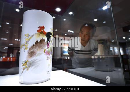 (190805) -- NANCHANG, Aug. 5, 2019 -- Mao Guanghui views his creation displayed at the exhibition hall of a ceramic research institute in Jingdezhen, east China s Jiangxi Province, Aug. 2, 2019. Mao Guanghui, a 56-year-old senior master of arts and crafts in Jiangxi Province, has been devoting himself to porcelain painting since the age of 13. As a third-generation disciple of Deng Bishan (1874-1930), one of the Eight Friends of Zhushan , a group of Jingdezhen artisans widely noted for their innovations in porcelain painting, Mao inherited not only the skills but also the art of creating porce Stock Photo