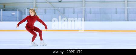 Talented and concentrated girl in red sportswear, figure skating athlete in motion, training on ice rink arena Stock Photo