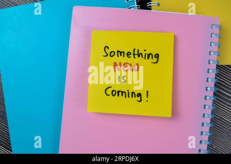 Concept of Something New is Coming! write on sticky notes isolated on Wooden Table. Stock Photo