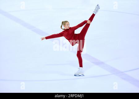 Talented, artistic and concentrated girl, figure skating athlete in motions, training on ice rink arena Stock Photo