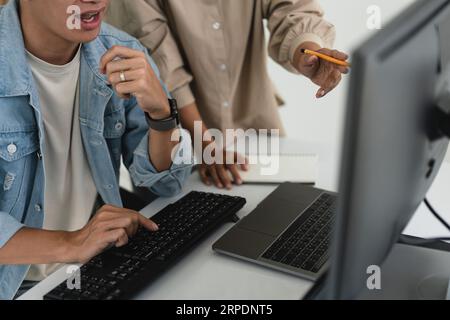 Two developer programmer discussing to checking code on monitor about programming to developing web. Stock Photo