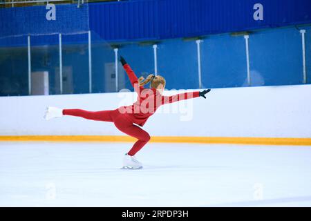 Talented, hardworking and concentrated girl, figure skating athlete in motions, training on ice rink arena Stock Photo