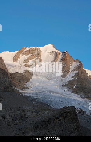 Gran Paradiso mountain and glacier view from chabod hut at sunset. golden hour, colored peak against blue sky. landscape Stock Photo