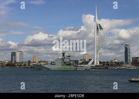 Passing the Spinnaker Tower as she sails towards her harbour berth: HMS Tyne is a Royal Navy river-class offshore patrol ship, and part of the fishery protection squadron which protects the waters around the United Kingdom. Stock Photo