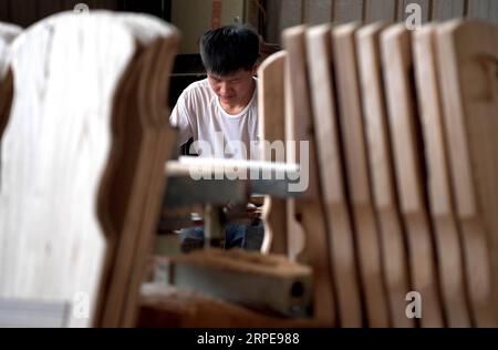 (190822) -- LANKAO, Aug. 22, 2019 -- A craftsman makes Guqin, a seven-string traditional Chinese instrument, at a workshop in Xuchang Village, Lankao County of central China s Henan Province, Aug. 21, 2019. The village of Xuyang makes full use of its paulownia wood resources and vigoriously develops musical instrument production. A total of 82 workshops producting over 20 kinds of musical instruments have so far emerged in the village and the annual output has reached 100 thousand. ) CHINA-HENAN-DEVELOPMENT-MUSICAL INSTRUMENTS PRODUCTION(CN) LixAn PUBLICATIONxNOTxINxCHN Stock Photo