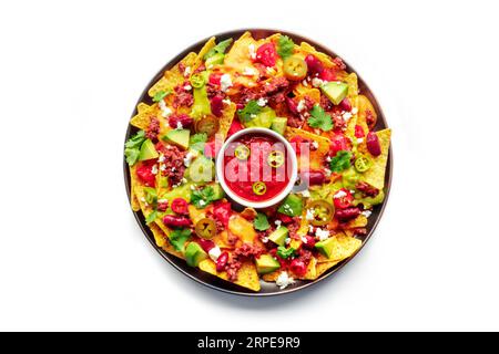 Loaded nachos. Mexican nacho chips with beef, overhead flat lay shot with guacamole sauce, cheese salsa, beans and peppers, isolated on a white background Stock Photo